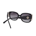 Side view of glossy black frame sunglasses with round metal temple detail