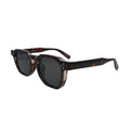 Three-quarter angle view of chunky tortoise shell square sunglasses showing full tortoise temple pattern and silver rivet hinge detail